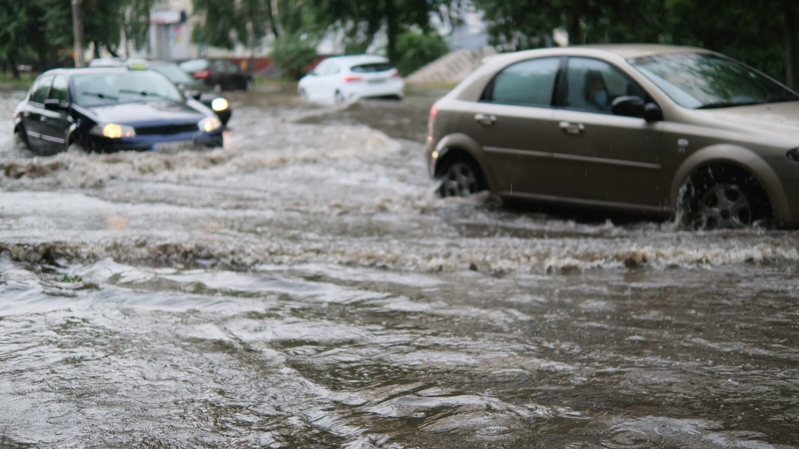Rainwater flooding a residential street after a storm.