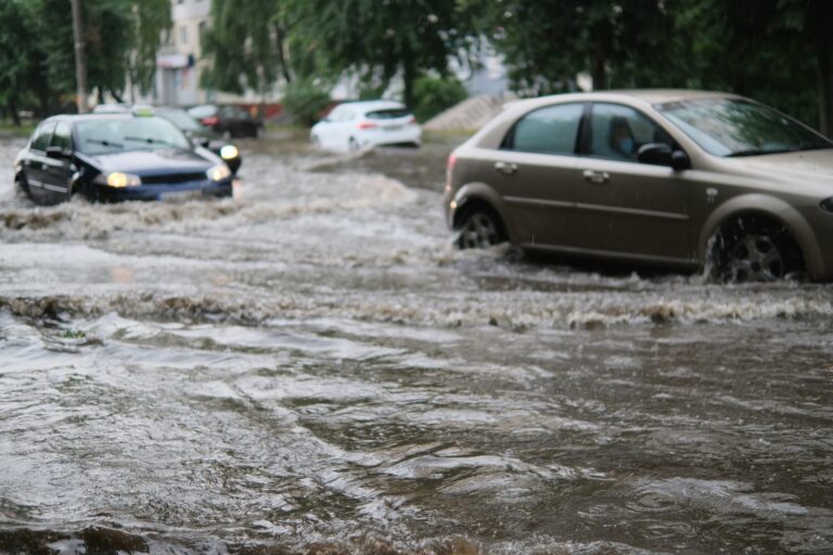 Rainwater flooding a residential street after a storm.