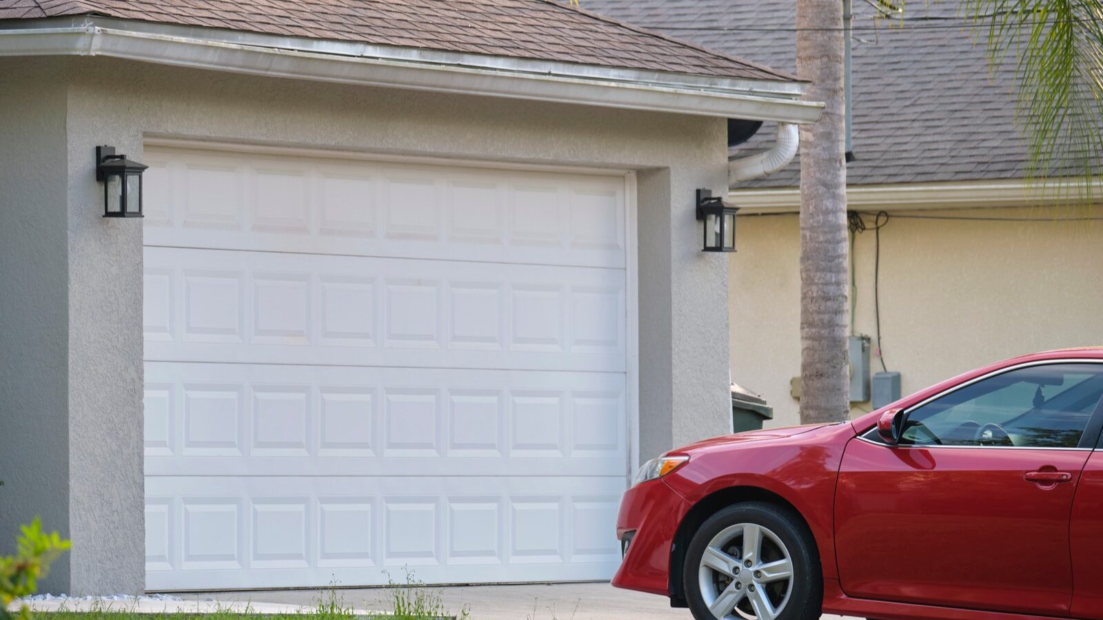 A car parked on the driveway of a suburban house.