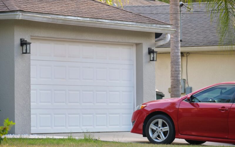 A car parked on the driveway of a suburban house.