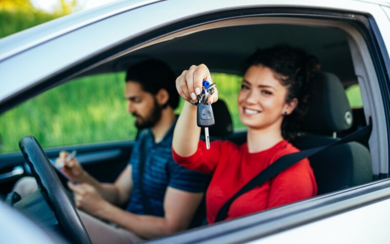 A driving instructor sitting beside a learner at the wheel.